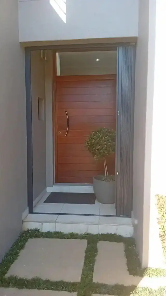 Front door retractable security gate with welcome mat